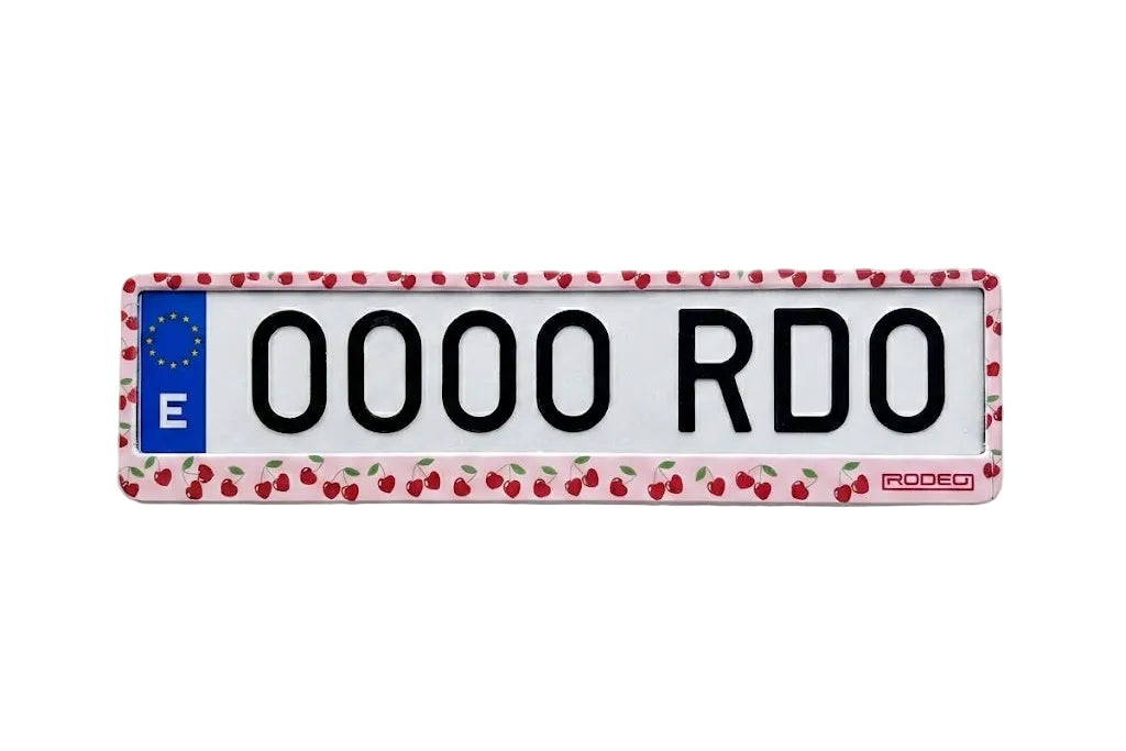 Portamatrículas RODEO de color rosa pastel con estampado de cerezas rojas. Estilo coquette aesthetic en matrícula europea.