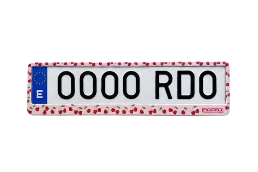 Portamatrículas RODEO de color rosa pastel con estampado de cerezas rojas. Estilo coquette aesthetic en matrícula europea.