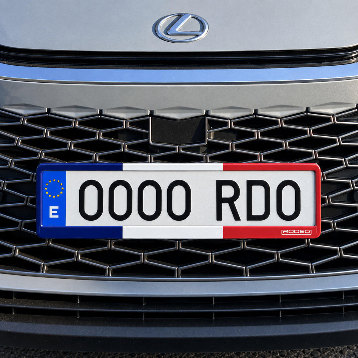 Portamatrículas Rodeo Francia azul, blanco y rojo bajo la parrilla delantera de un Lexus LBX.